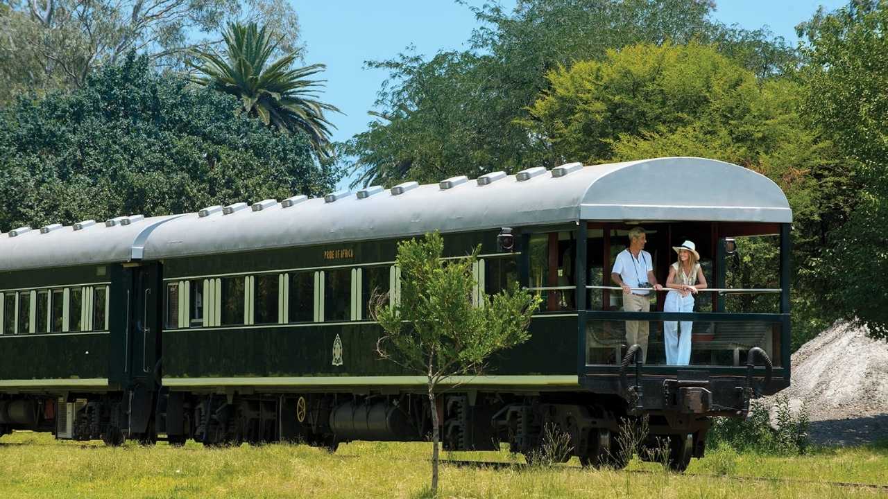 Rovos Rail luxury train departing from a station in Southern Africa.