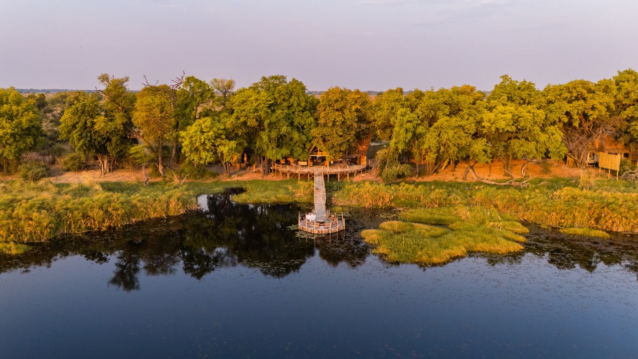 view of main lodge at Sitatunga Private Island with water in foreground and bush in background, Botswana luxury safari