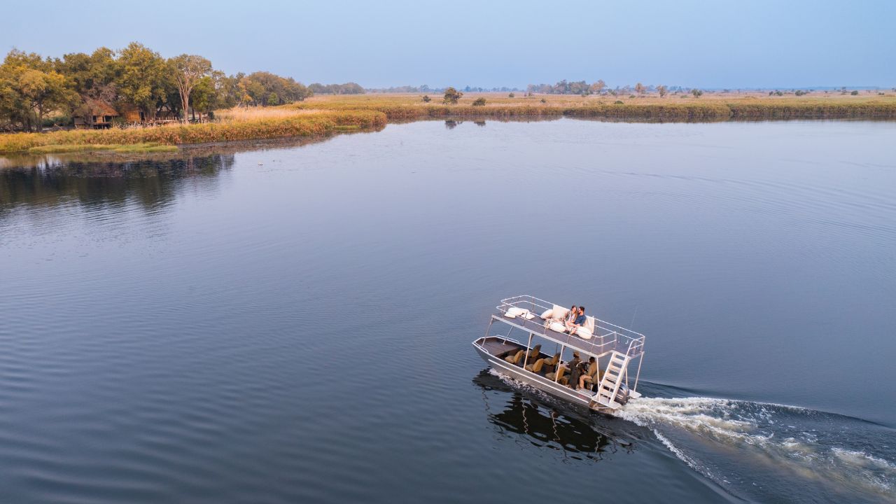 River cruise arriving at the main lodge of Sitatunga Private Island, Botswana, on the Okavango Delta.