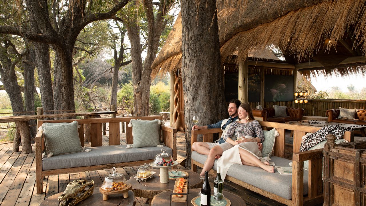 Couple enjoying views of the Okavango Delta from a deck at Sitatunga Private Island, Botswana.