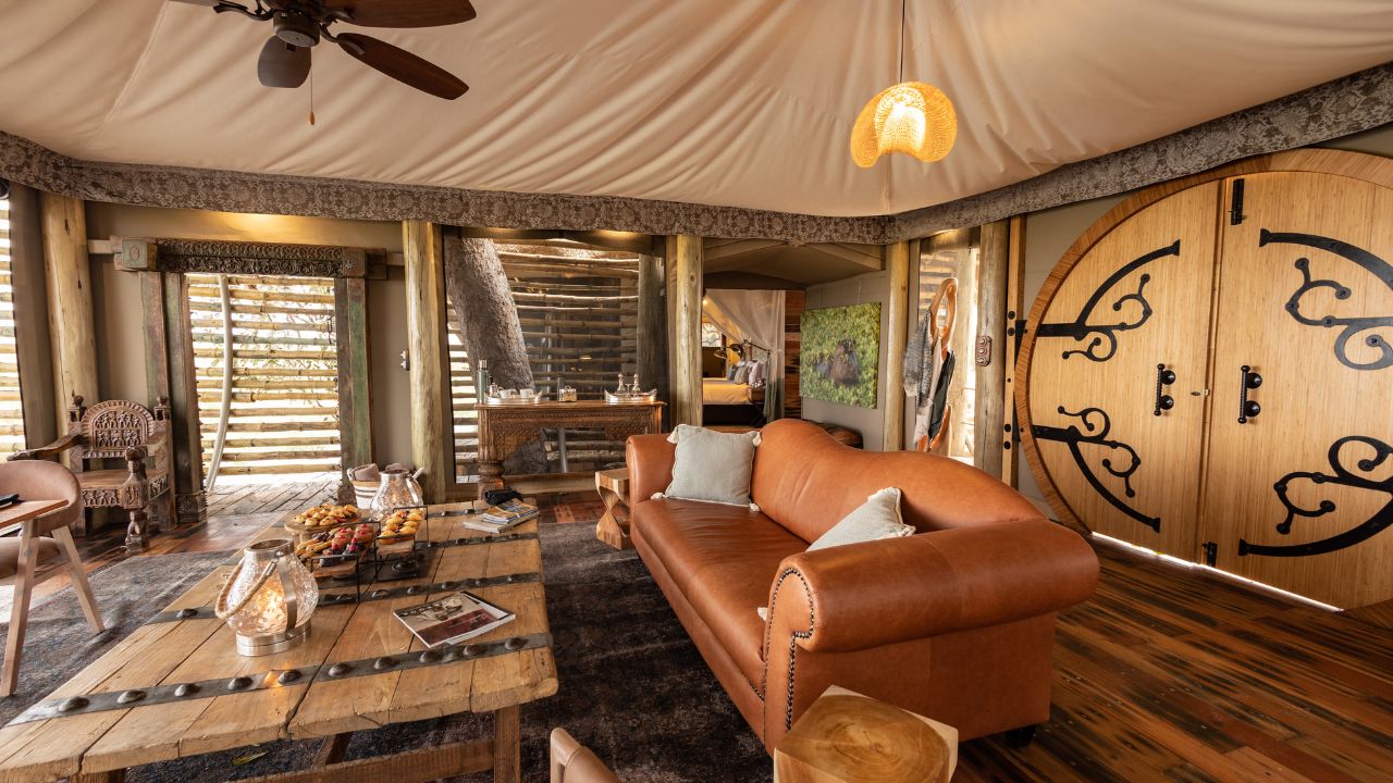 Lounge area in a guest room at Sitatunga Private Island with leather couch and wooden table, Botswana.