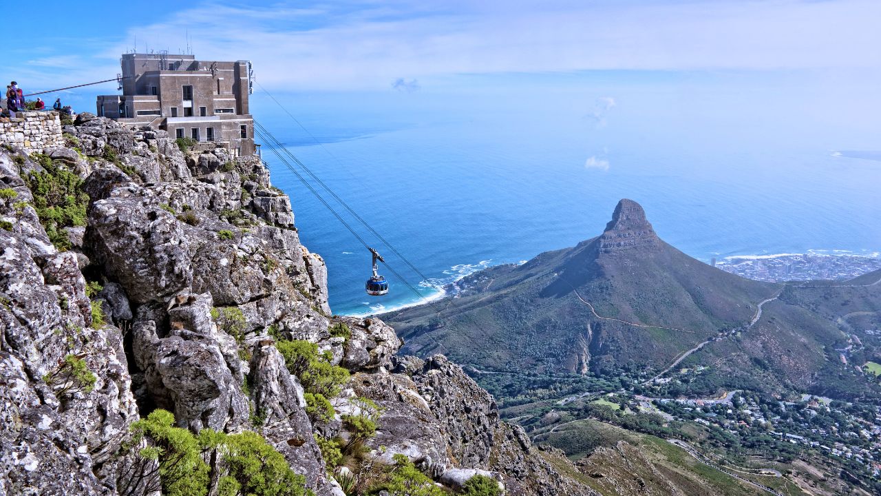 Table Mountain cable car with Lion’s Head and ocean in background