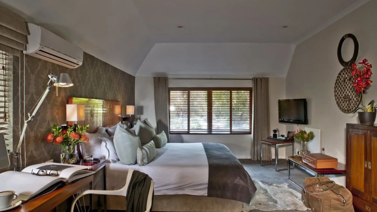 Side view of double bed in luxury guest suite at Peech Boutique Hotel