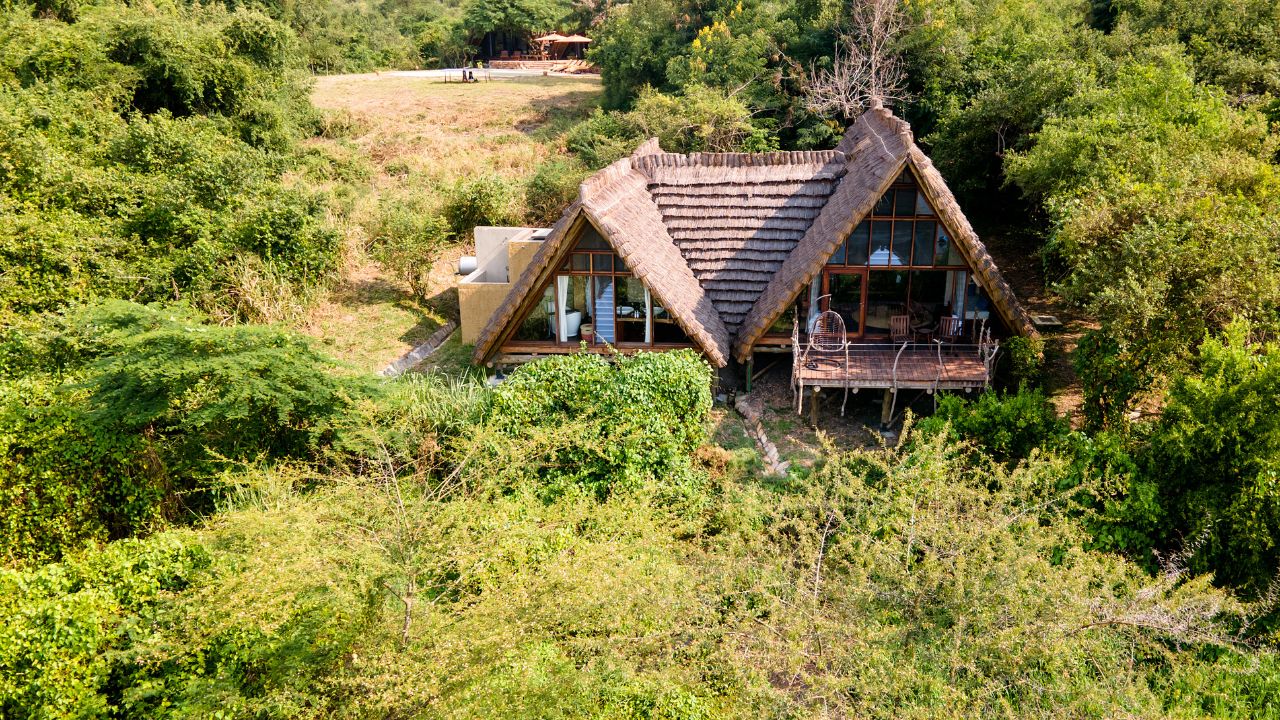 Aerial front view of Nile Safari Lodge with thatched roof and bush surroundings
