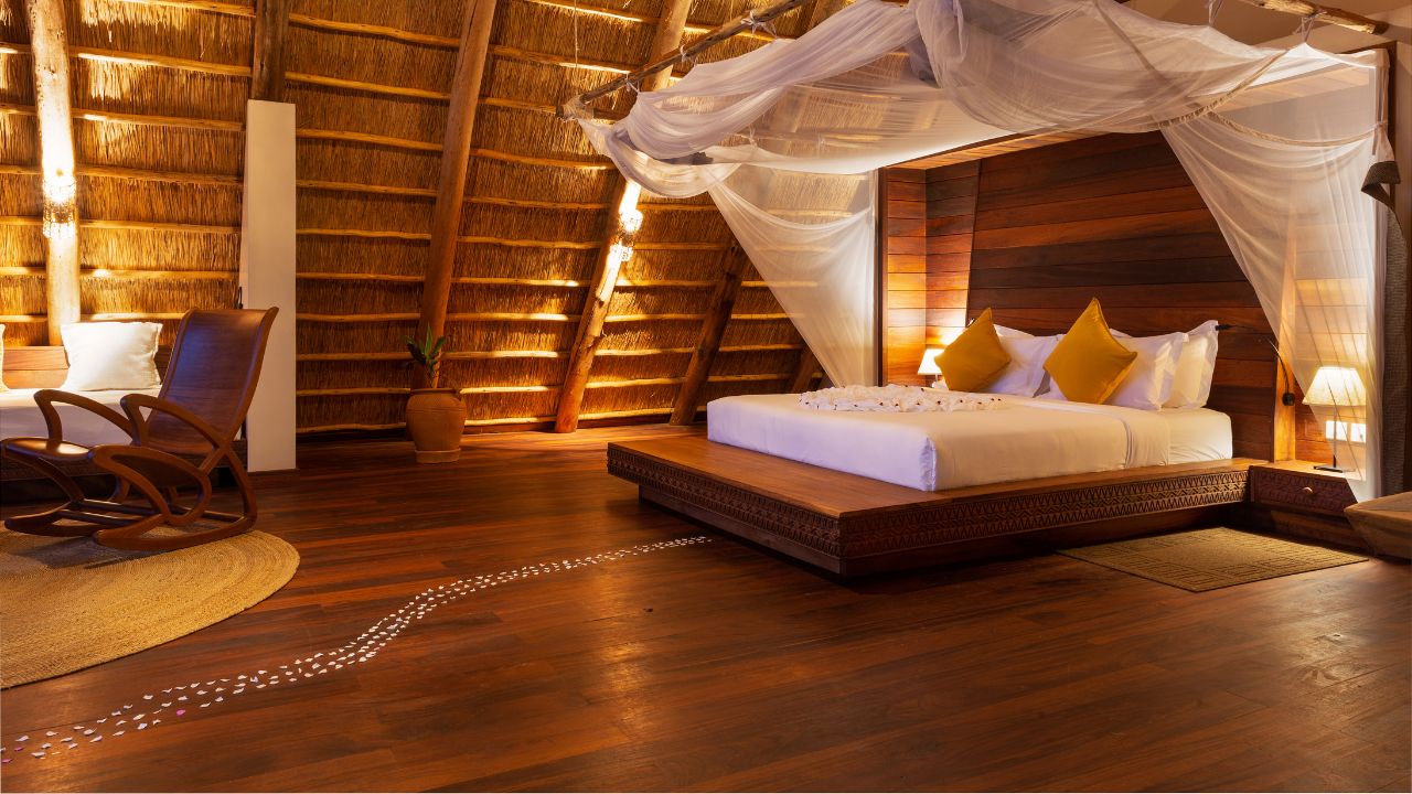 Front view of double bed with wood finishes and thatched roof, Uganda safari lodge