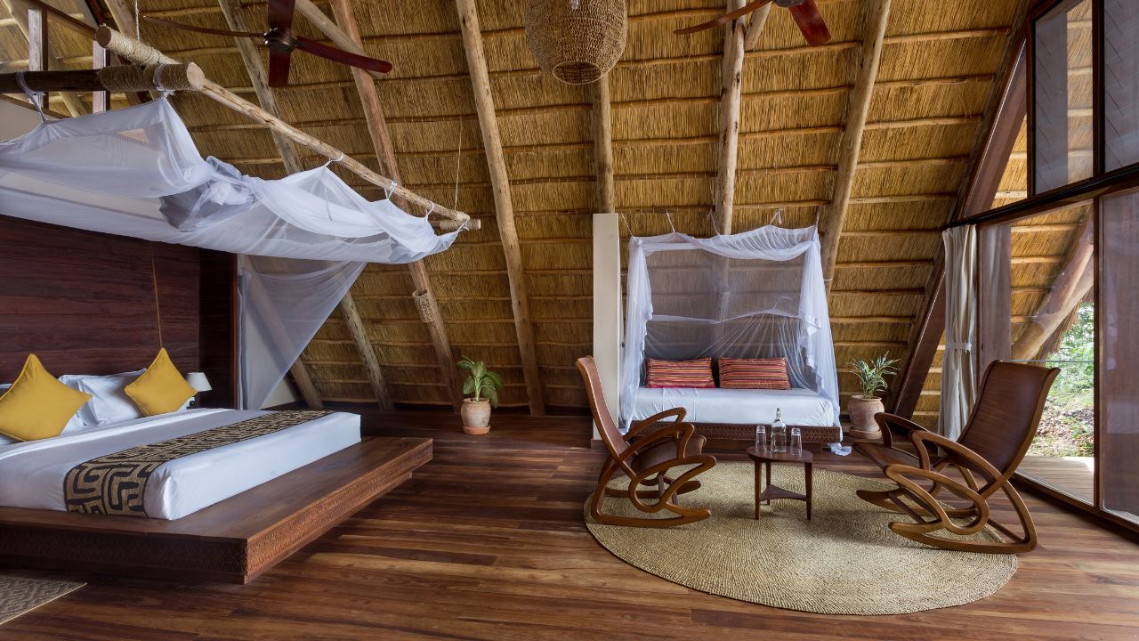 Side view of guest room with wood accents, thatched roof and large windows