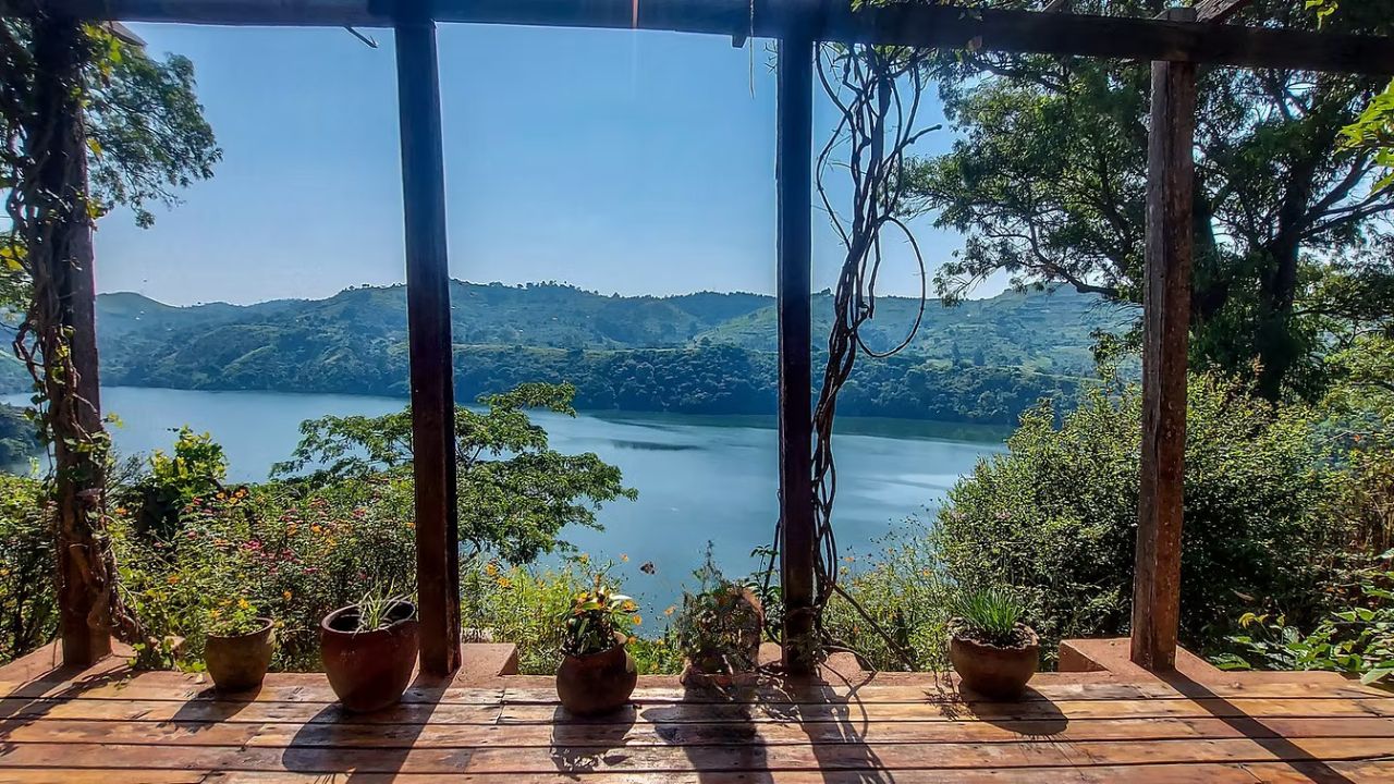 View from Ndali Lodge deck overlooking crater lake and extinct volcano landscape in Uganda.