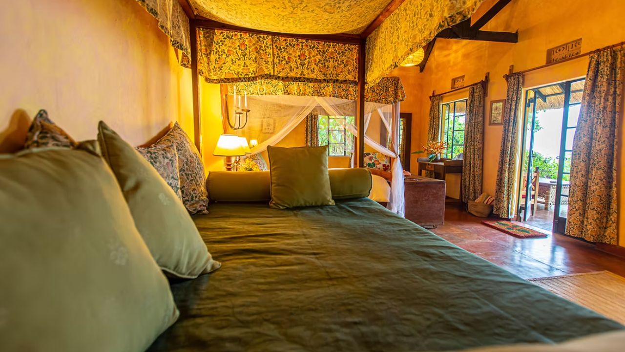 Side view of spacious guest room at Ndali Lodge with large windows and jungle views.