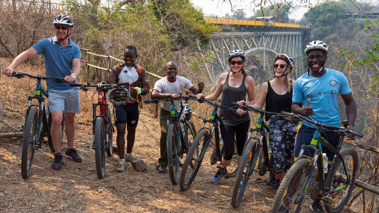 Guide and guests on bicycle tour near Victoria Falls Bridge Zimbabwe