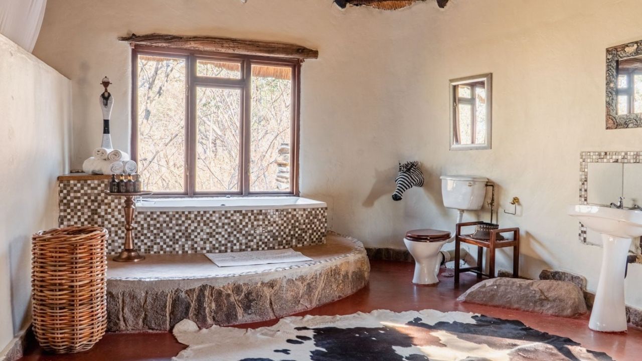 Luxury bathroom with step-up bath overlooking bush at Amalinda Lodge