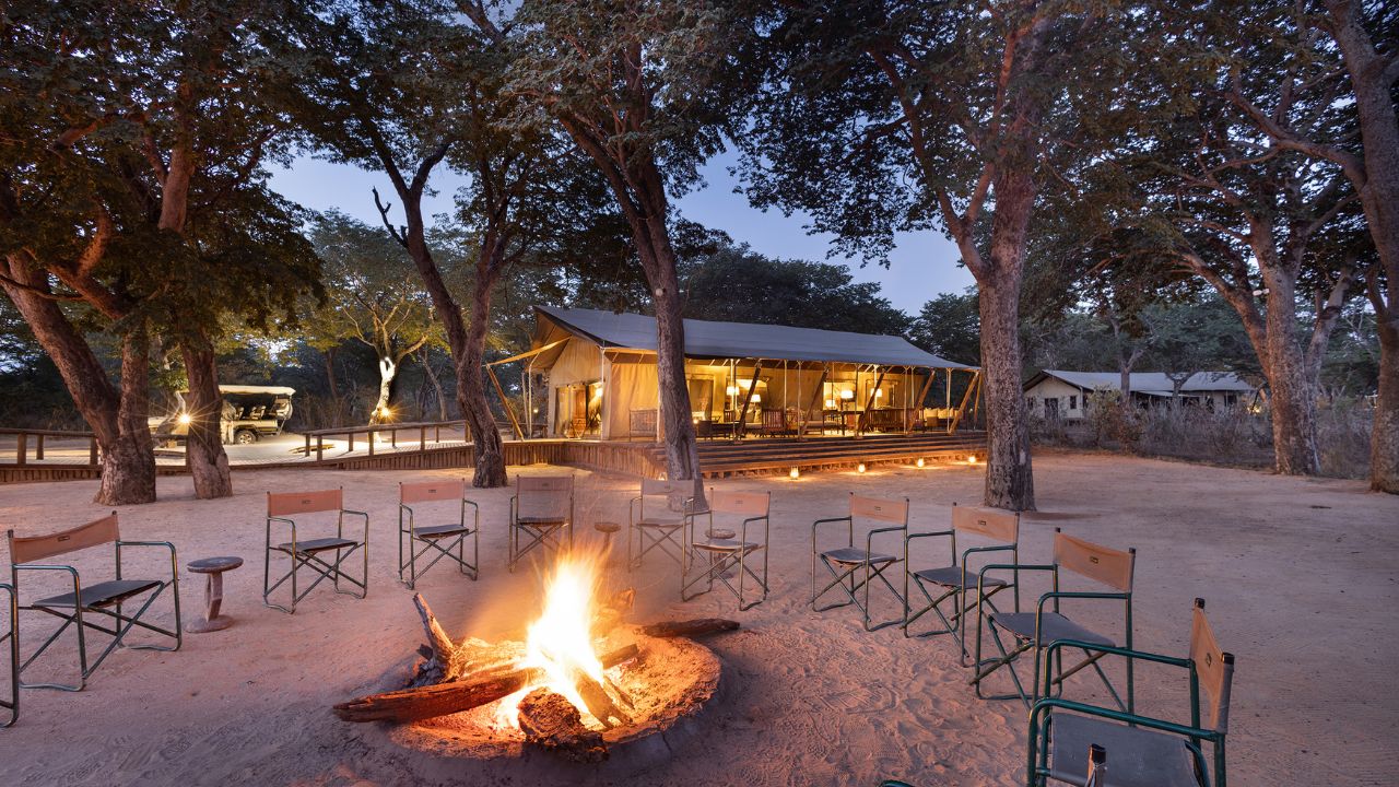 Boma fire at Verneys Camp with lodge in background, Hwange National Park Zimbabwe