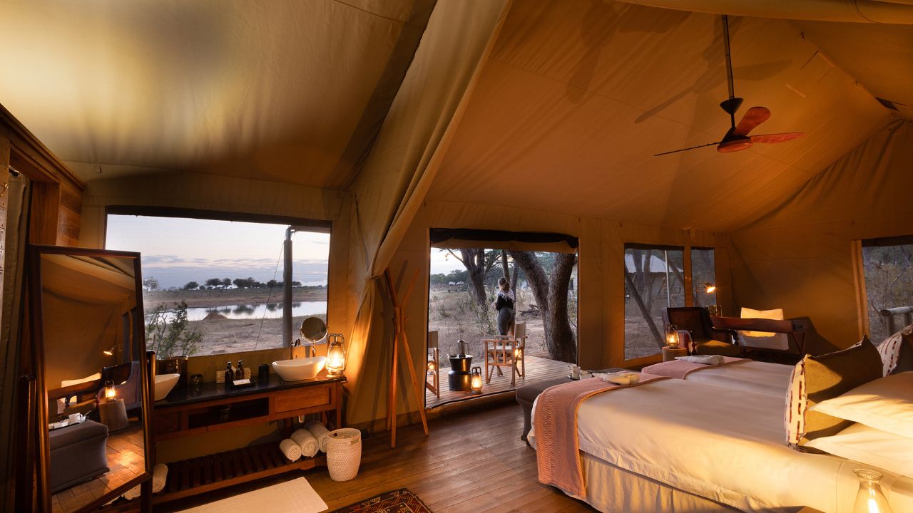 Luxury tented suite double bed at sunset, Verneys Camp Hwange