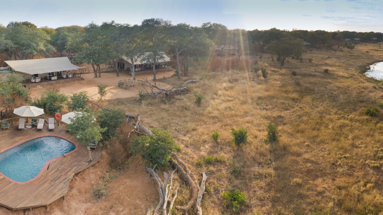 Elevated view of main lodge and swimming area with bush, Verny’s Camp