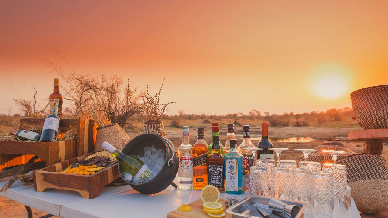 Sunset drinks table set with African sunset in background, Verny’s Camp