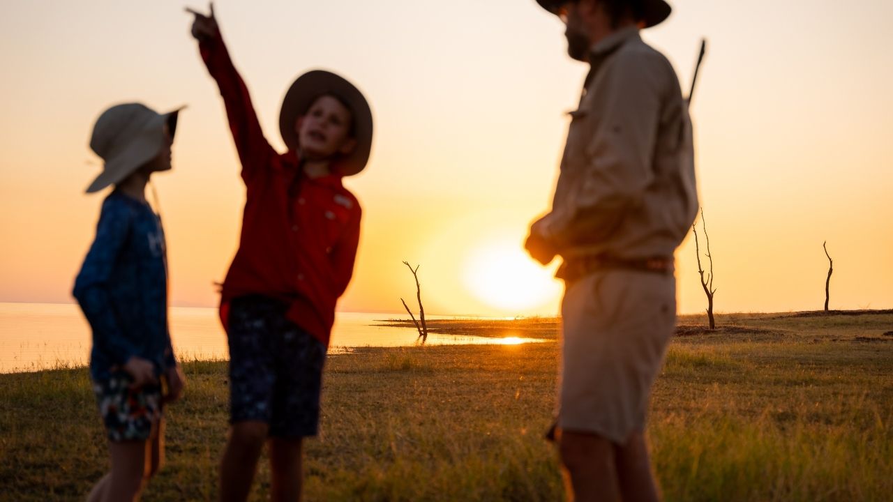 Young boy pointing out activity on Lake Kariba next to safari guide
