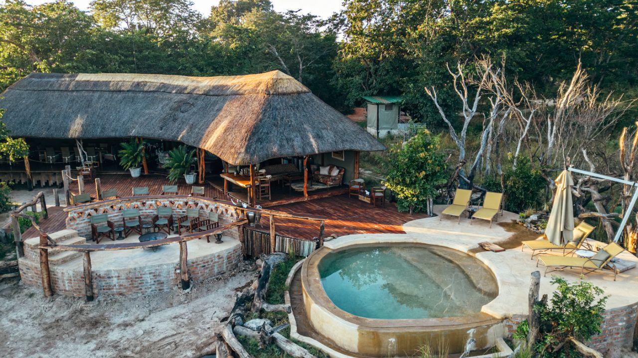 Swimming pool and thatched deck at Khulu Bush Lodge with boma campfire