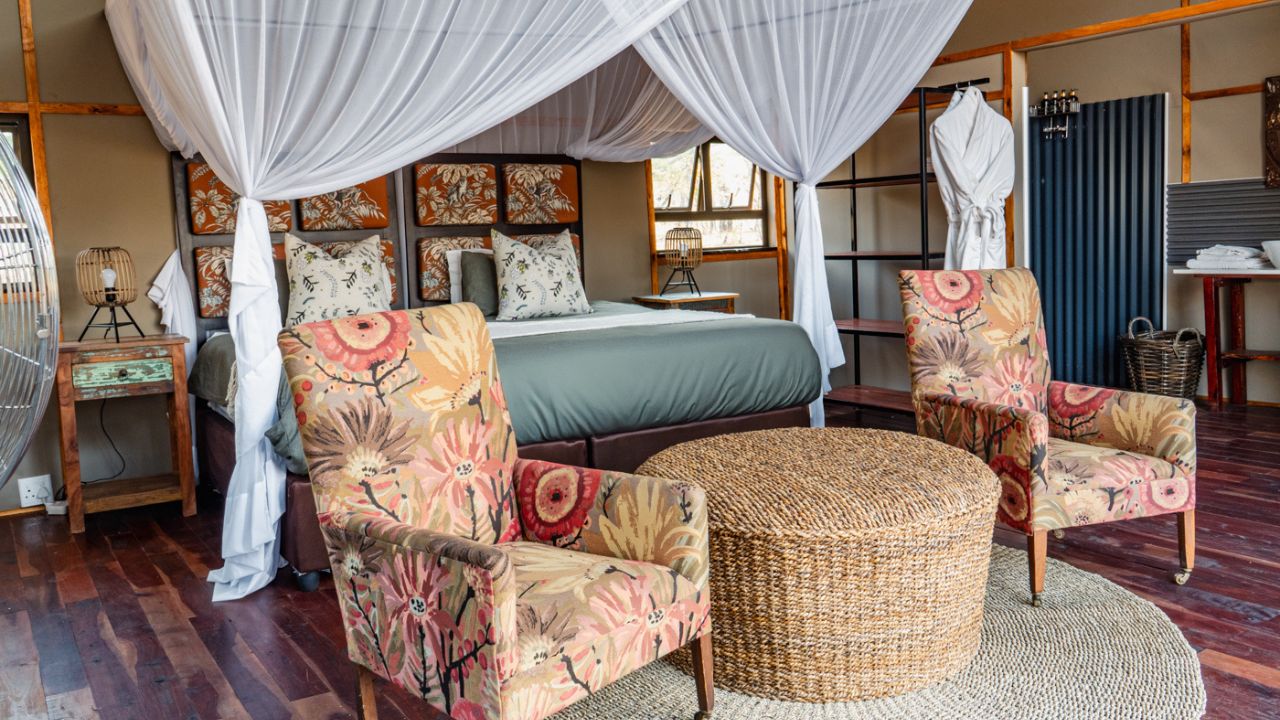 Double guest room at Kulu Bush Camp with mosquito net and lounge chairs