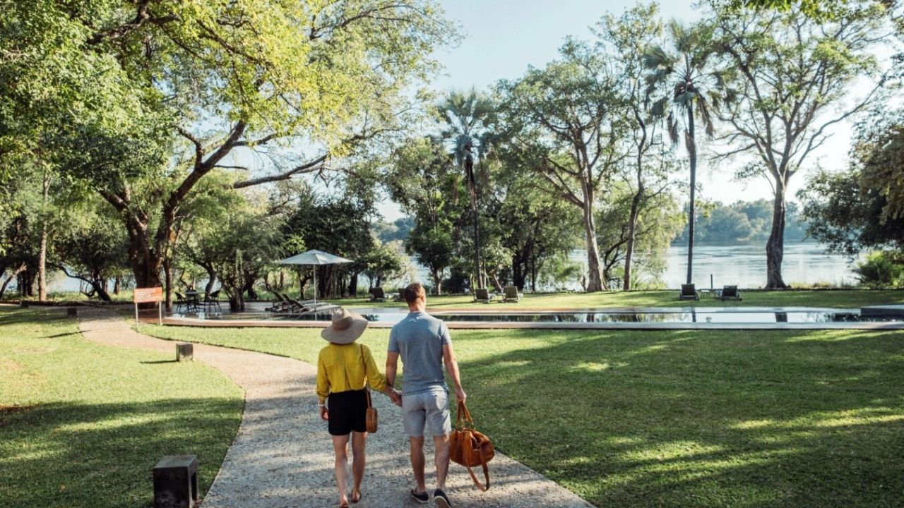 Couple walking Palm River Hotel gardens Victoria Falls