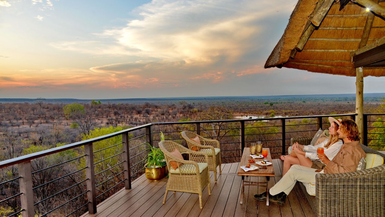 Romantic couple on main deck at Victoria Falls Safari Club watching sunset