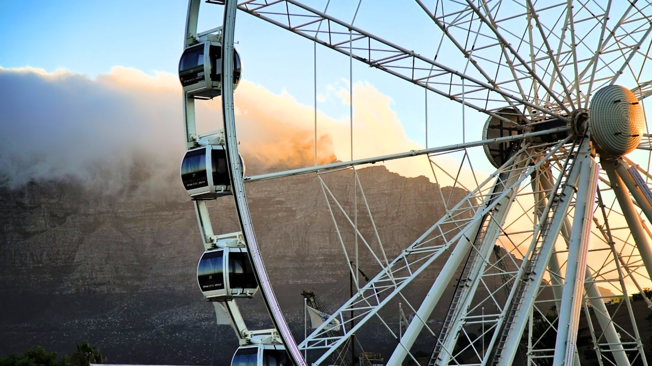 Ferris wheel at Victoria & Alfred Waterfront, Table Mountain behind clouds, Cape Town.