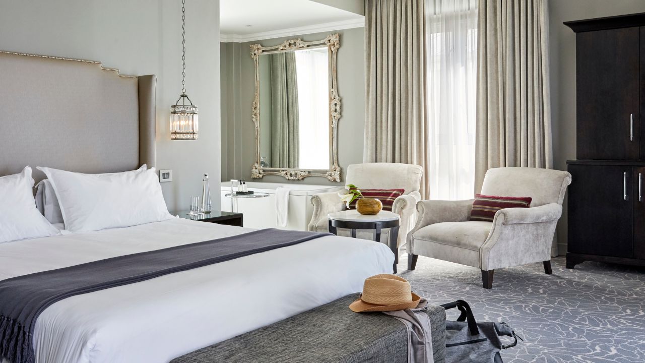 Junior suite interior with occasional chairs, modern black and white décor.
