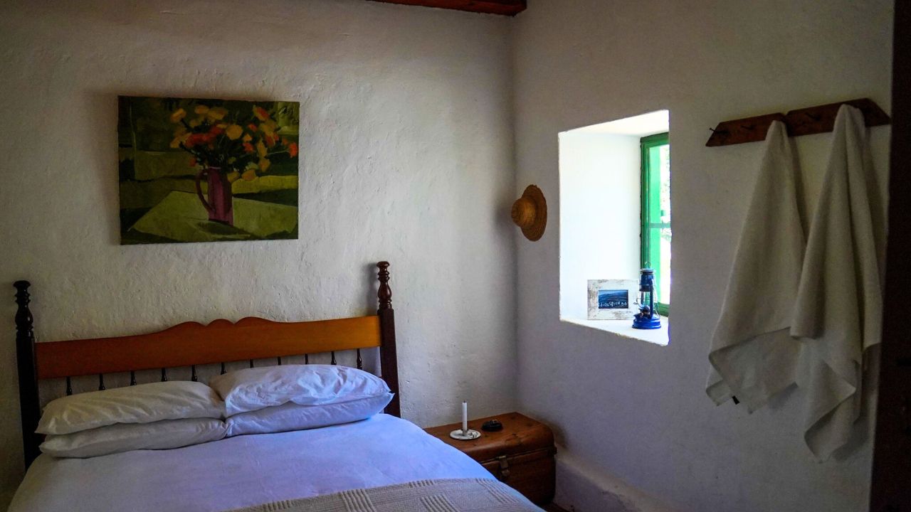 Rustic farm-style guest room with double bed and window Bakkrans.
