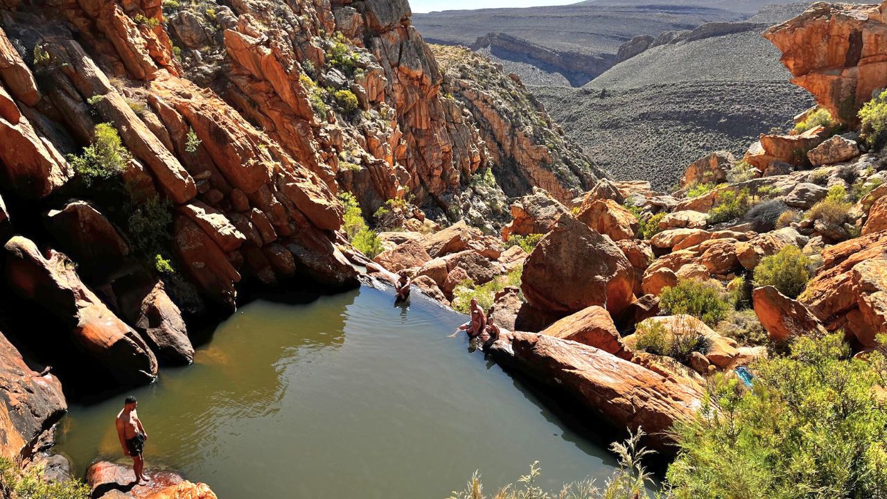 Guests swimming in natural mountain rock pool at Bakkrans.