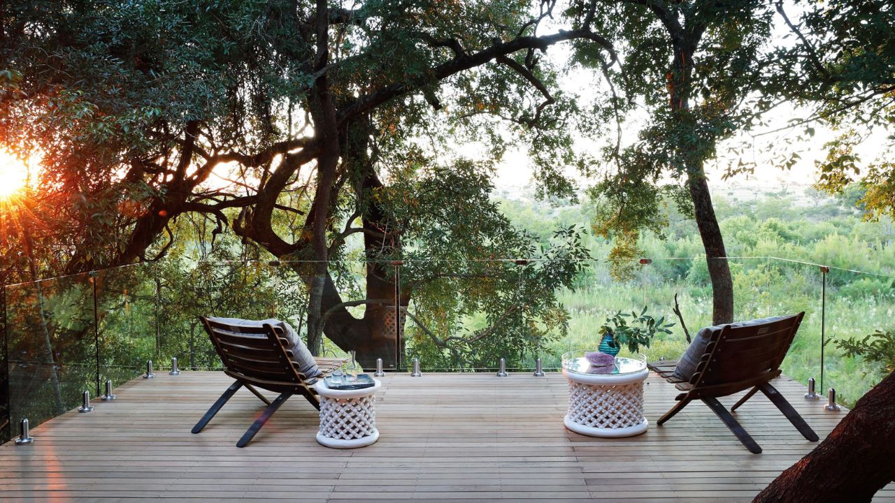 Romantic sundowner setup with two chairs on deck overlooking Londolozi bush.