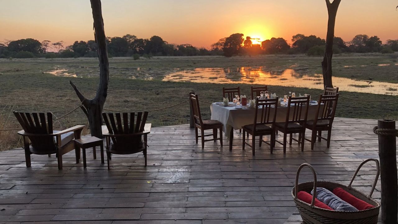 Guest deck at Musekese Camp during sunset, dinner prepared and ready.