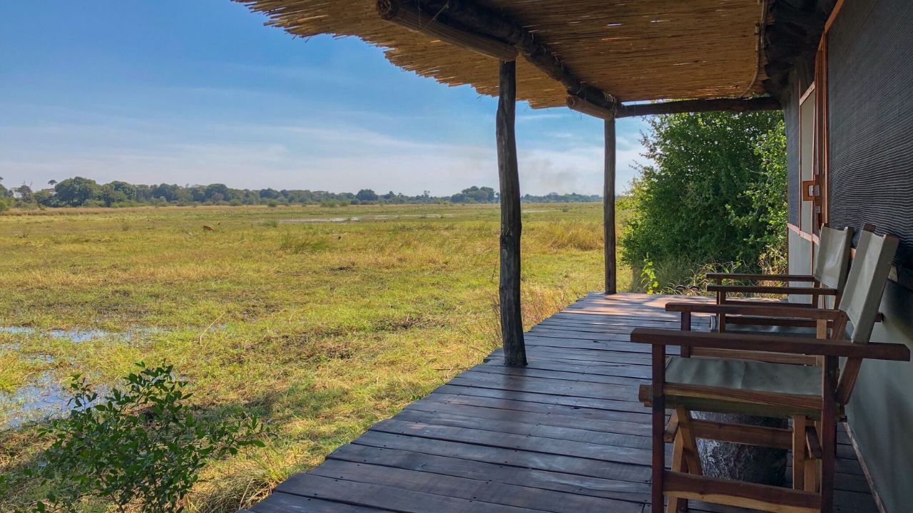 View from guest tent deck overlooking the Zambian bush, sunrise lighting.