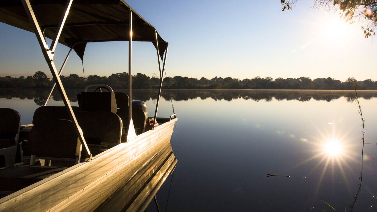 Safari houseboat on calm waters, Zambian river.