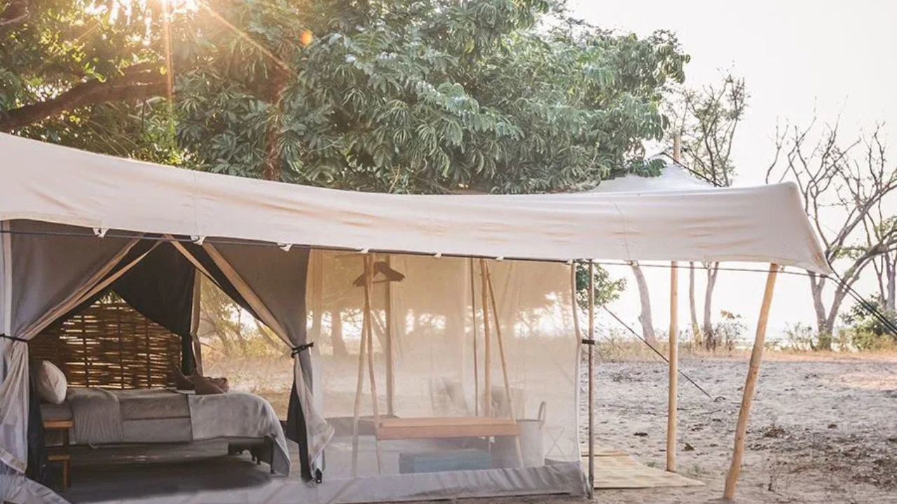 Open view of Chula Island Camp tented accommodation with double bed, spacious interior, and African bush visible outside.