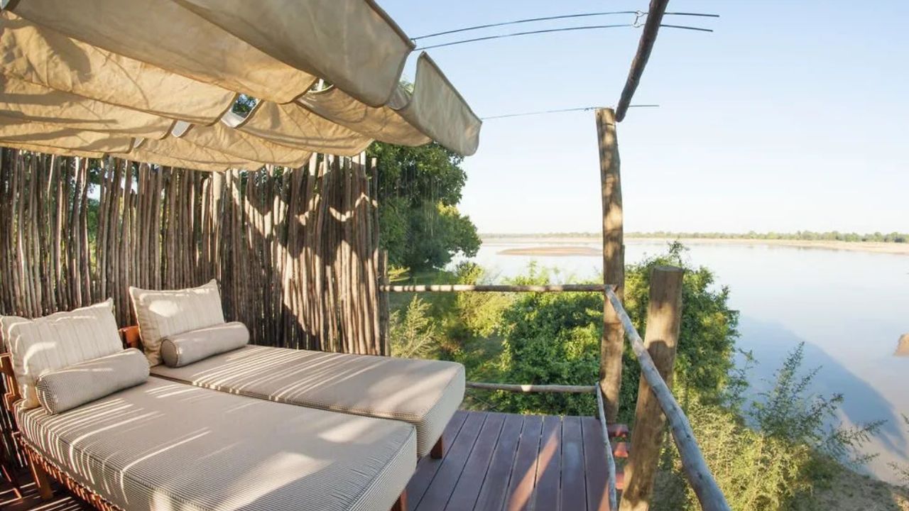 Luxury guest tented accommodation with double bed, soft interior colors