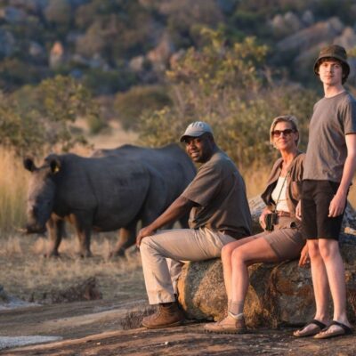 Guests observing rhino up close on walking safari Africa.