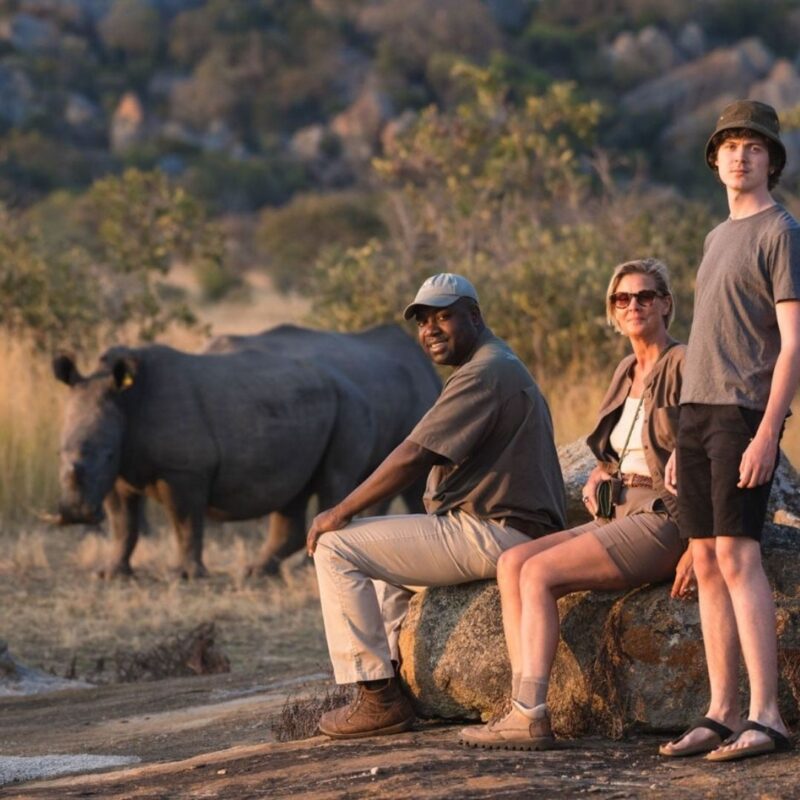 Guests observing rhino up close on walking safari Africa.