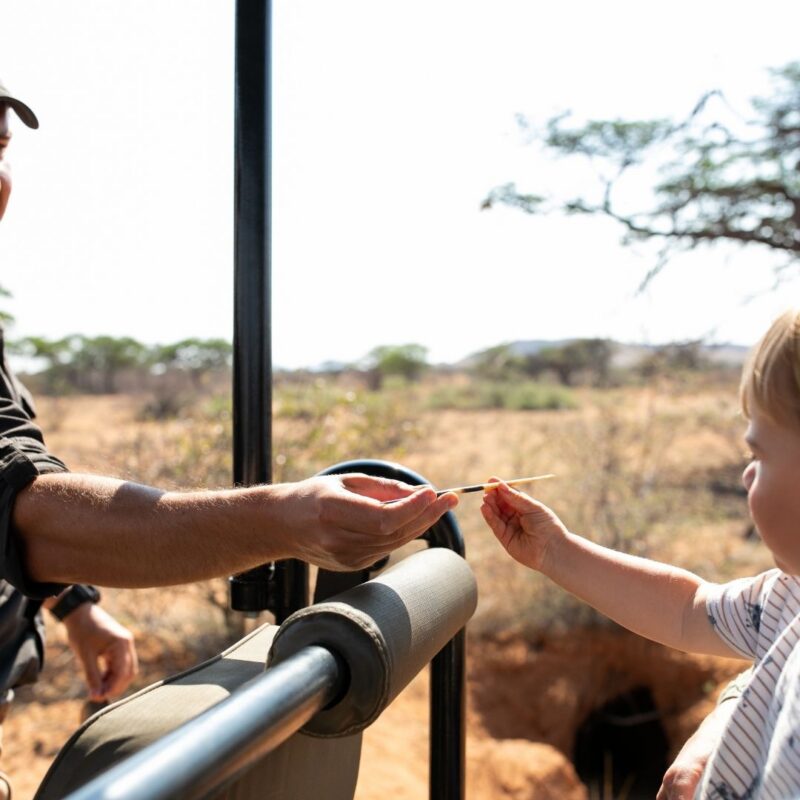 Safari guide showing porcupine quill to child at Tswalu Kalahari.