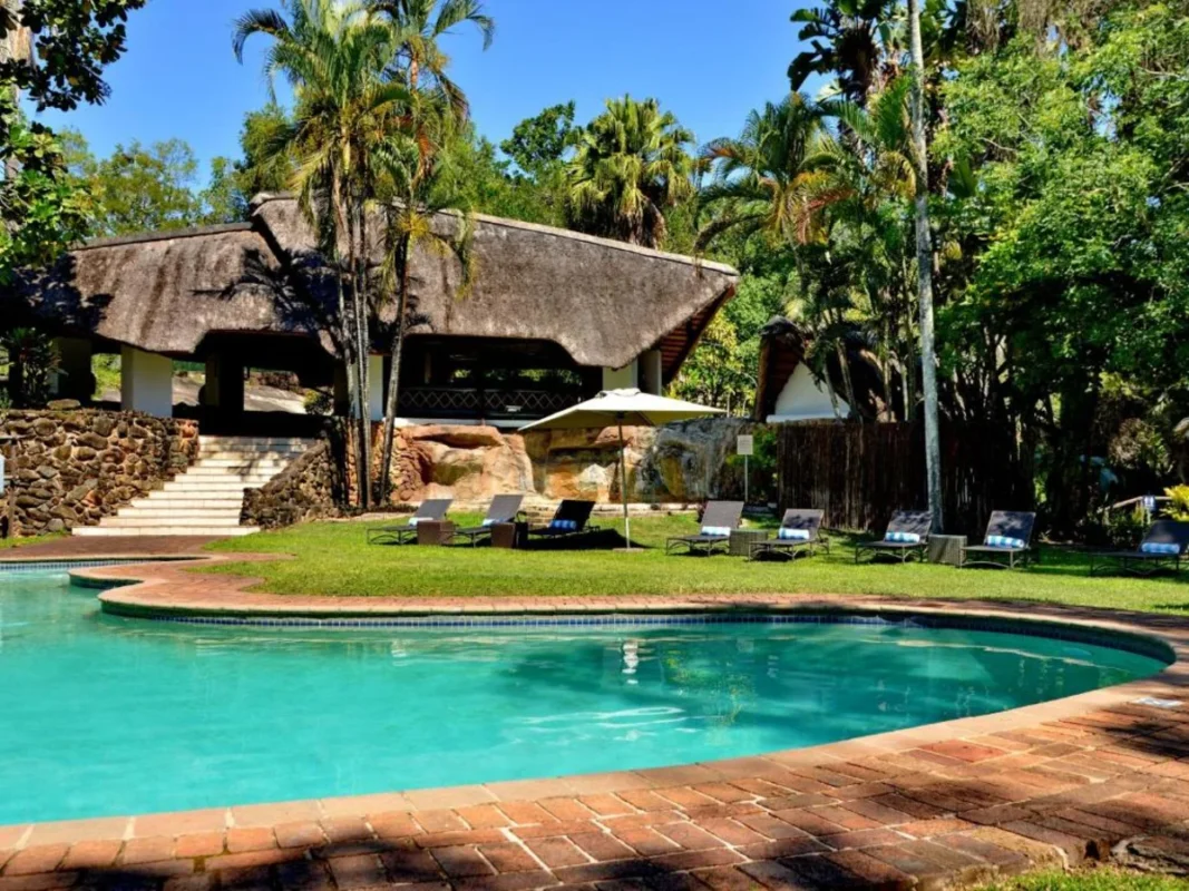 Swimming pool and thatched guest area at ANEW Resort Hazyview.