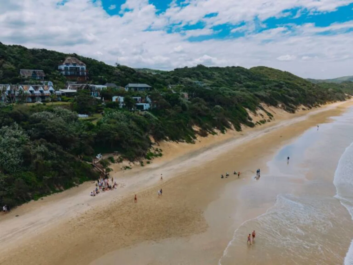 Crawford's Beach Lodge viewed from the ocean with beach guests.