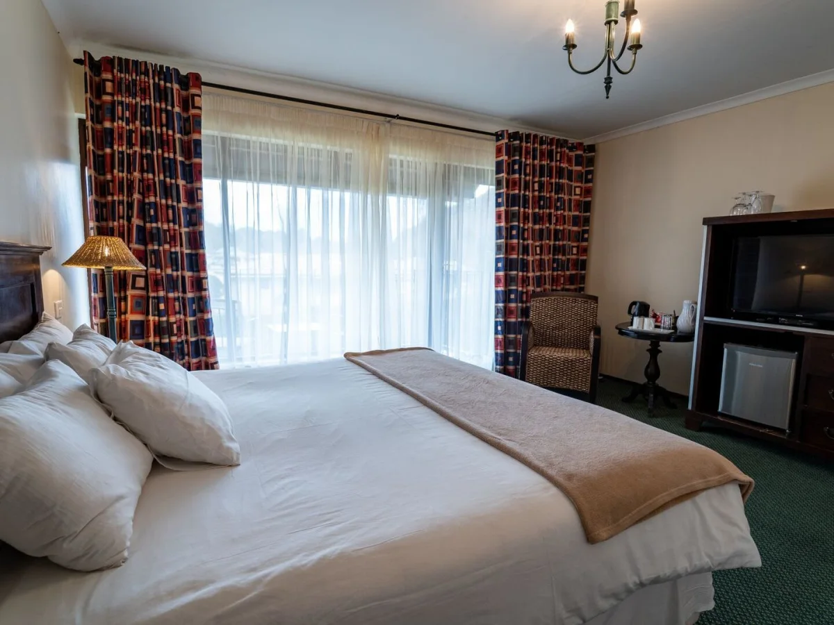 Double room with TV and balcony at Gooderson Drakensberg Gardens Resort.