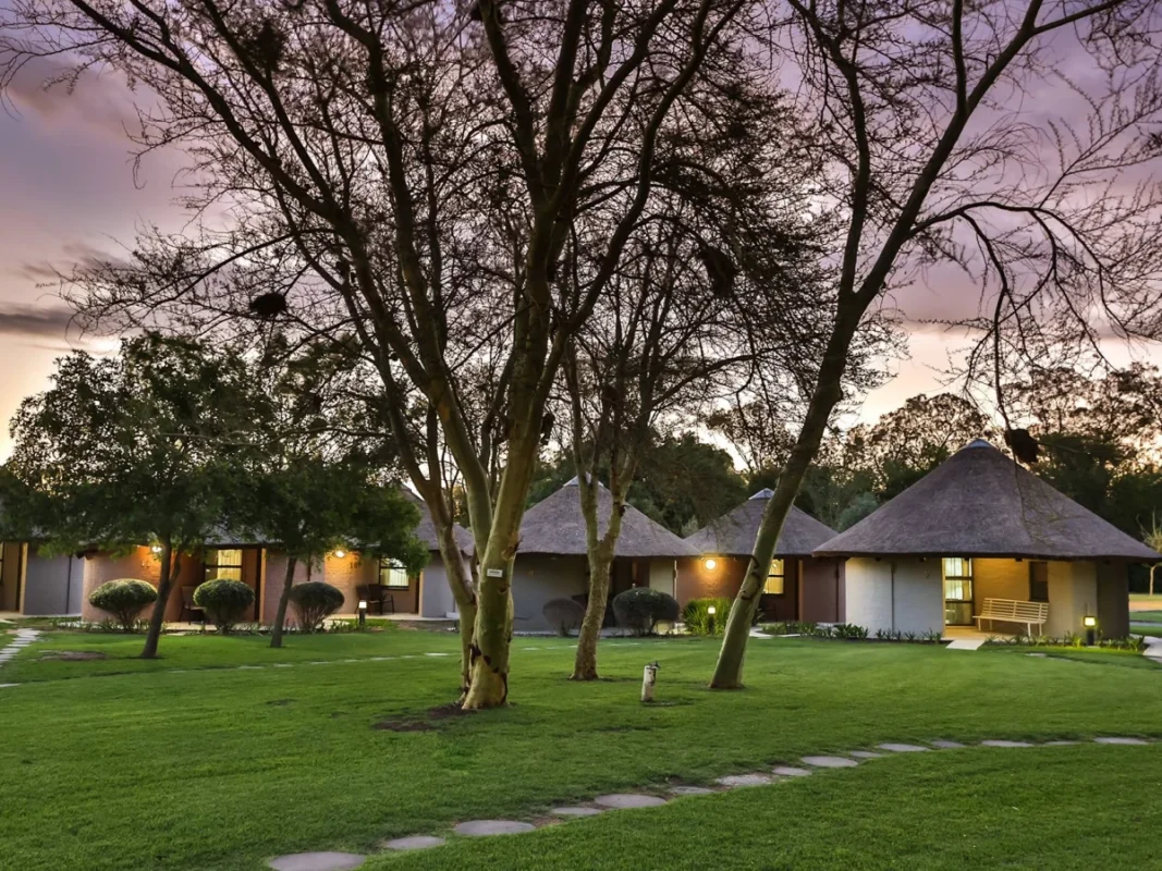 Protea Hotel Riempie Estate chalets at dusk in Oudtshoorn South Africa.