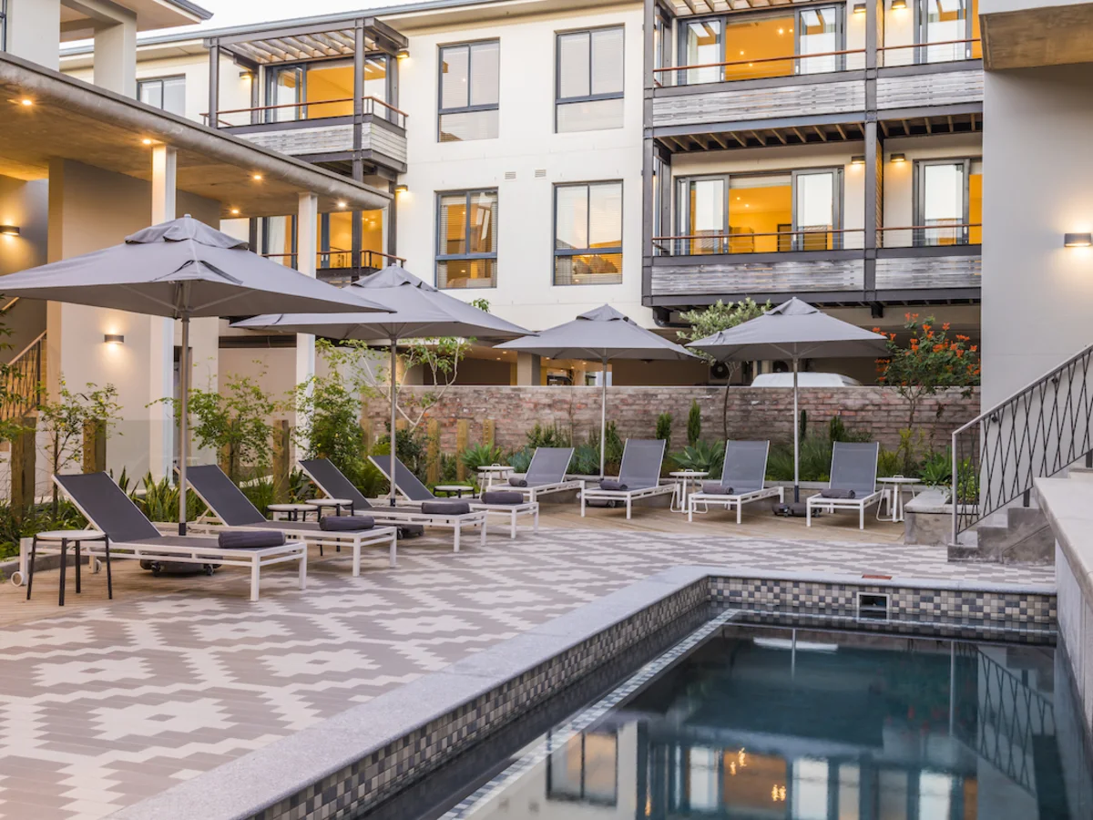 Outdoor swimming pool and deck chairs at aha The Rex Hotel Knysna.