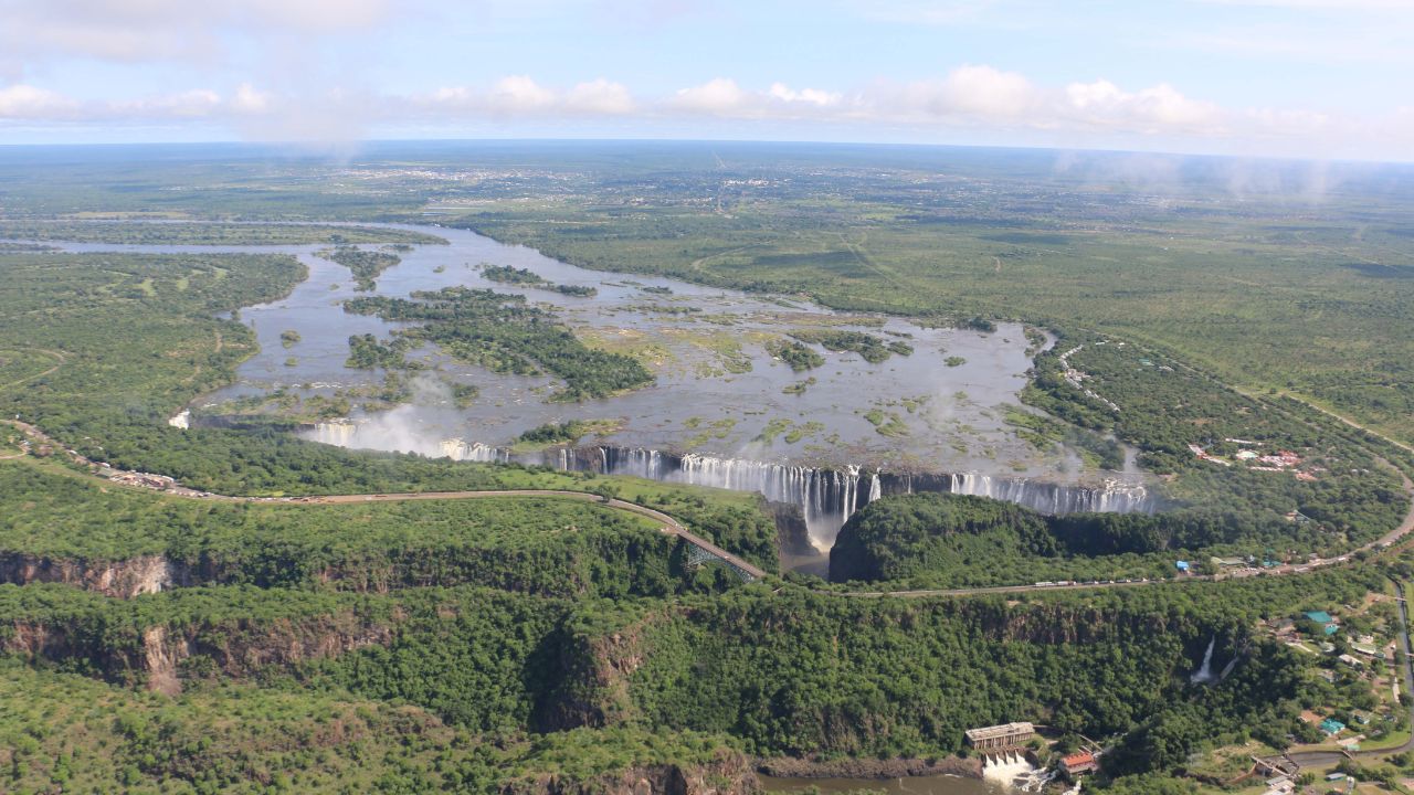 Best time to visit Victoria Falls during summer with lush green vegetation surrounding the falls.